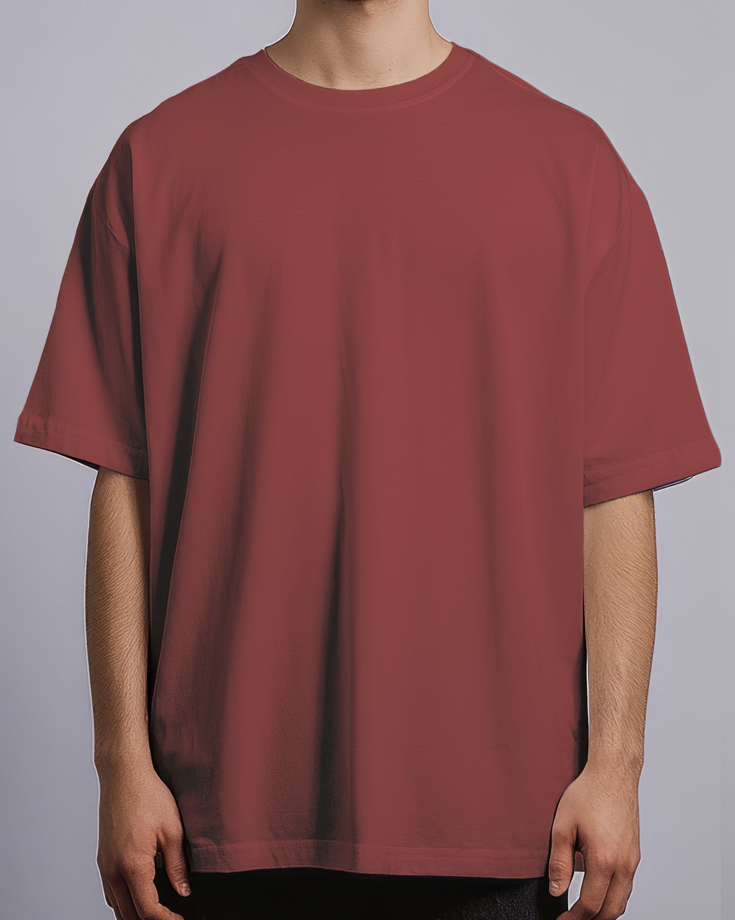 Maroon t-shirt worn by a person on a gray background
