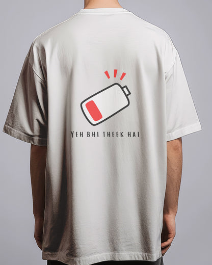 Person wearing a t-shirt with a battery icon and text on the back against a gray background